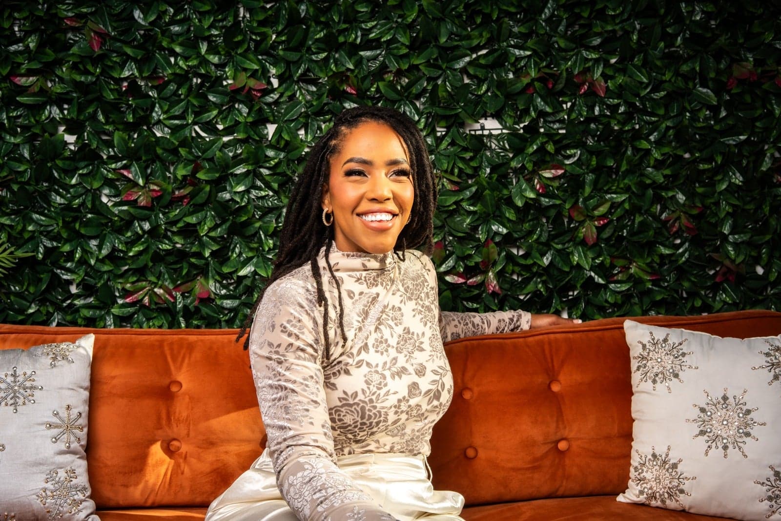 Amber Brangman, founder and lead planner, seated on a vintage orange sofa